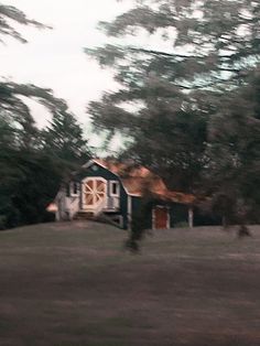 a blurry photo of a house in the middle of a field with trees around it