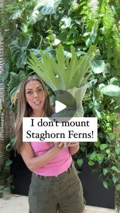 a woman standing in front of a plant with the words i don't mount staghorn ferns