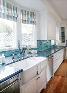 a large kitchen with white cabinets and blue counter tops on the counters is pictured in this image