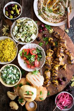 an assortment of food on a wooden platter including meats, vegetables and other foods