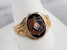 This antique fraternal ring represents the Junior Order of United American Mechanics! The enamel detailing is crisp and bold, and the scrolling designs on the ring's shoulders have a textured relief that feels luxurious. What a great ring! Metal: 10K Yellow and Rose Gold Materials: Black, Red, White, and Blue Enamel Top Measurements: 12 x 15 mm, Oval Ring Size: 11.75 Marks: "OB 10K" Stamped on the inside band Formal Engraved Enamel Signet Ring, Antique Enamel Ring Collectible, Traditional Engraved Signet Ring Collectible, Antique Black Enamel Signet Ring, Antique Black Enamel Rings For Collectors, Ceremonial Heirloom Enamel Ring In Yellow Gold, Heirloom Yellow Gold Enamel Ring For Ceremonial Occasions, Ceremonial Heirloom Yellow Gold Enamel Ring, Antique Enamel Rings For Collectors