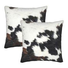 two black and white cowhide pillows with brown spots on the sides, one is square