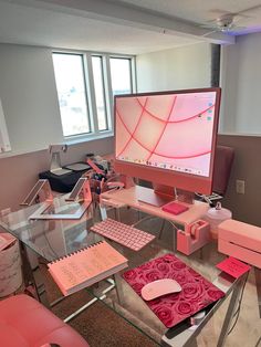 a desk with a computer monitor, keyboard and mouse on it in front of a window