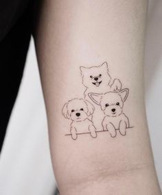 a small dog and cat tattoo on the arm