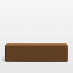 a brown bench sitting on top of a white wall