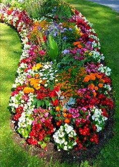 a flower bed in the grass with people walking by