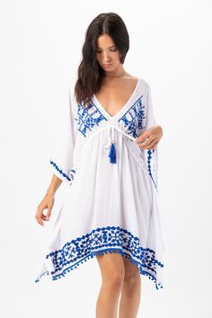 Elevate your beach wardrobe with our Mykonos Mini Dress. This exquisite embroidered coverup allows you to embrace the artistry of seaside fashion. With its intricate detailing and effortless charm, this coverup is sure to make you feel like a beach goddess wherever your adventures take you. Details: 100% Rayon Hand Wash in Cold Water and Lay Flat to Dry Features: Unlined, V-neckline, Embroidered detail, Tassel tie closure to cinch waist for an adjustable fit, Sides drape lower, Billowing short s Embroidered Kaftan For Beach Cover-up, Blue Boho Dress For Beach Cover-up, Blue Boho Summer Dress For Beach Cover-up, Summer Bohemian Kaftan With Embroidered Hem, Bohemian Summer Kaftan With Embroidered Hem, Bohemian Kaftan With Embroidered Hem For Summer, Summer Embroidered Dresses For Beach Season, Beach Vacation Dresses With Floral Embroidery, Floral Embroidery Beachwear Dress For Festival