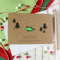 a christmas card with an image of a green dinosaur on it and trees in the background