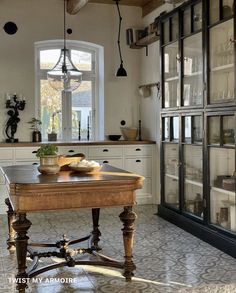 a kitchen with an old fashioned table in the center