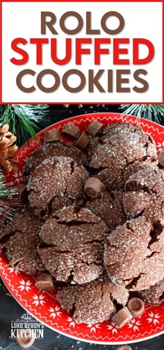 a red plate topped with cookies covered in powdered sugar and surrounded by pine cones