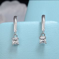 These 1.00 Ctw Lever Back Dangling Princess Cut Diamond Earrings are GIA certified with a H color and SI2 clarity. The lever back design with dangling princess cuts make them an exquisite addition to any collection. Metal : 14K White Gold Setting Type : Prong NO. of Stones : 2 Total Carat Weight : 1.00 Ct. Tw. Type : Natural Diamond Shape : Princess Cut Carat Weight : 1.00 Ct. (0.50 Ct Each, GIA Certified) Cut Quality : Excellent-Very Good Color : H Clarity : SI2 Princess Cut Diamond Earrings, Princess Cut Diamond, Princess Cut Diamonds, Diamond Shape, Back Design, Princess Cut, Diamond Shapes, Natural Diamonds, Diamond Earrings