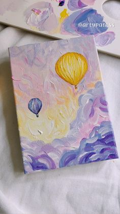 an acrylic painting of two hot air balloons