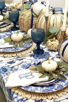 a blue and white table setting with pumpkins