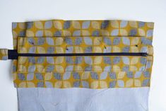 a piece of fabric with yellow and grey circles on it, sitting on a white surface