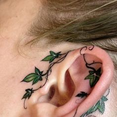 a close up of a person's ear with vines on it and leaves around the ear