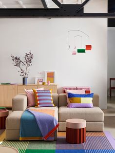 a living room filled with lots of furniture and colorful pillows on top of it's couch