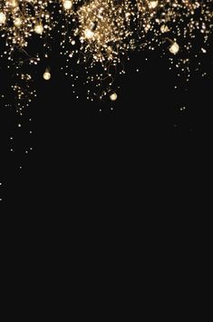 a black background with gold sparkles in the air