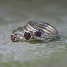 Deep, rich collection of gemstones.Scarlet red garnet is combined with purple amethyst and pink topaz.Five handmade sterling silver stacking rings.  Three smooth ring bands are set with faceted gemstones.  Two ring bands are given a hammered and polished finish. Wear them all together, mix and match, or just wear one beautiful ring at time.5mm Garnet4mm Purple Amethyst4mm Pink TopazEach ring is approximately 1/16th of an inch.  Together the stack is just over one quarter inch wide (5/16").This s Anniversary Stackable Garnet Gemstone Rings, Anniversary Ruby Ring With Gemstone Accents In Sterling Silver, Fine Jewelry Sterling Silver Stackable Rings With Gemstone Accents, Sterling Silver Stackable Rings With Gemstone Accents, Purple Gemstone Stackable Rings As Gift, Purple Sterling Silver Birthstone Ring With Gemstone Accents, Purple Ruby Rings For Gifts, Purple Ruby Ring For Gift, Purple Ruby Rings As Gifts