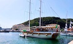 there is a boat that is docked in the water near some buildings and boats on the water