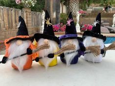 three little gnomes are sitting on the table outside with brooms in their hands