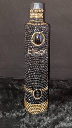 the bottle is decorated with black and gold beads