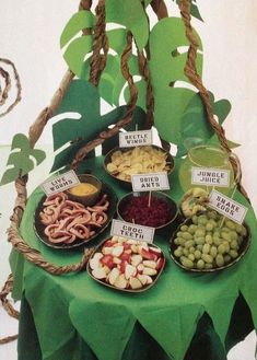 a table topped with lots of different types of food on top of a green cloth