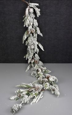 snow covered pine cones and branches on a gray tablecloth with black backgroud