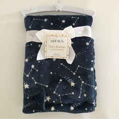 a blue blanket with white stars on it and a tag hanging from the back of it