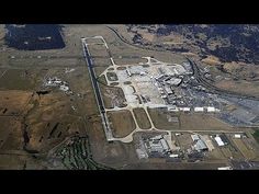 an aerial view of a large airport with lots of grass and dirt on the ground