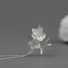 Introducing our exquisite pendant featuring a delicate design of cherry blossoms crafted in sterling silver. The intricate details of the flowers are beautifully highlighted with gold plating on the stamens, adding a touch of elegance and sophistication. The pendant captures the essence of spring, symbolizing renewal and beauty. It hangs gracefully from a matching sterling silver chain, making it a timeless accessory suitable for any occasion. Elegant Blossom Jewelry For Anniversary, Delicate Spring Jewelry For Anniversary, Delicate Jewelry For Spring Anniversary, Delicate Jewelry For Anniversary In Spring, Elegant Blossom-colored Spring Jewelry, Elegant Spring Blossom Colored Jewelry, Elegant Spring Anniversary Jewelry, Blossom Colored Flower-shaped Sterling Silver Jewelry, Blossom Color Sterling Silver Flower Jewelry