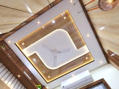 an overhead view of a clock on the ceiling in a room with stairs and lights