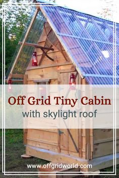 an off grid tiny cabin with skylight roof in the grass and text overlay reads off grid tiny cabin with skylight roof