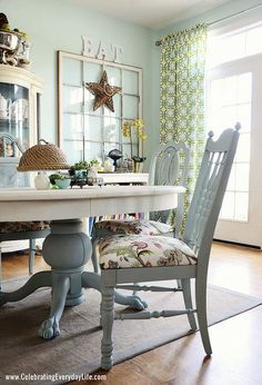 a dining room table with two chairs and a mirror on the wall in front of it