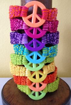 a stack of crocheted bracelets sitting on top of a wooden stand