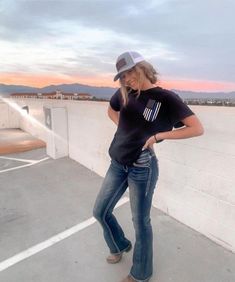 a woman standing on top of a roof next to a building