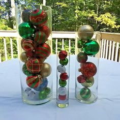 two clear vases filled with ornaments on top of a table