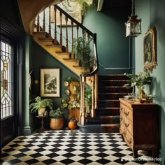 a staircase with potted plants and pictures on the wall next to it, along with a checkered black and white floor