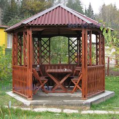 a wooden gazebo sitting on top of a lush green field