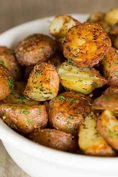 a bowl filled with potatoes covered in seasoning