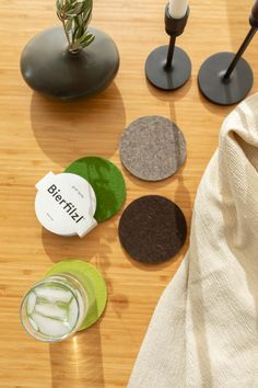 several coasters are arranged on a table with a plant in the corner and a bottle of water next to them