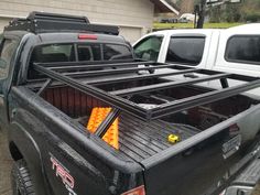 the truck is parked in the driveway with its bed up and there are other trucks behind it