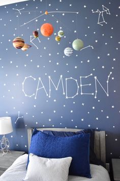 a bed room with a neatly made bed and a wall painted with the word camden