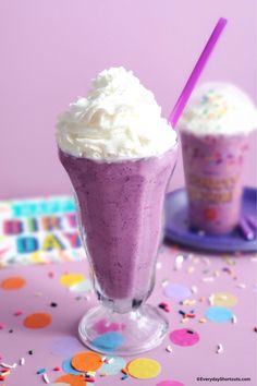 two glasses filled with ice cream and sprinkles on top of a table