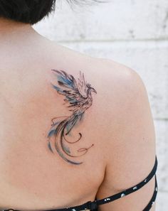 the back of a woman's shoulder with a bird tattoo on her left arm