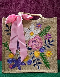 a bag with a pink ribbon and flowers on it