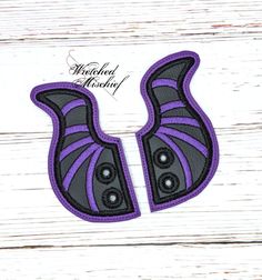 two purple and black wings on a white wooden background with the words,'halloween machine '