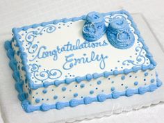 a blue and white congratulations cake with baby shoes on it