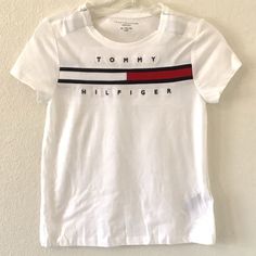 Nwot Tommy Hilfiger Big Girl's Adaptive T-Shirt Short Sleeve. This T-Shirt Is Perfect For Girls Who Love Casual And Comfortable Clothing. Made Of 100% Cotton And Featuring A Crew Neck With Pullover Closure, This Shirt Is Breathable And Stretchy, Making It Ideal For Summer, Fall, And Spring Seasons. It Comes In White With A Solid Pattern, Logo Accent, Machine Washable, Made In India. Pullover, With Hook And Loop Closure Please Verify With Measures Run Small M Shoulder To Shoulder 12” Armpit To Ar Tommy Hilfiger Letter Print Tops For Spring, Tommy Hilfiger Tops With Letter Print For Summer, Tommy Hilfiger Graphic Tee For Spring, Tommy Hilfiger Tops With Logo Print For Spring, Tommy Hilfiger Crew Neck Shirt With Letter Print, Trendy Tommy Hilfiger Tops With Graphic Print, Tommy Hilfiger Logo Print T-shirt For Spring, Tommy Hilfiger Graphic Tee With Letter Print, Tommy Hilfiger Short Sleeve Top With Letter Print