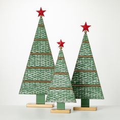 two green christmas trees with red stars on top and one is made out of wood