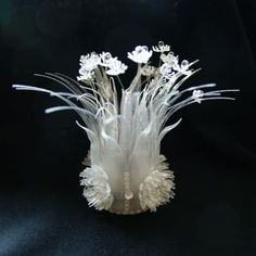 a vase with white flowers in it on a black background